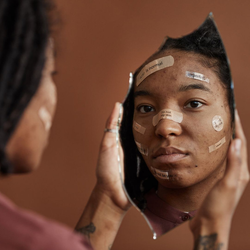 Woman looking in broken mirror